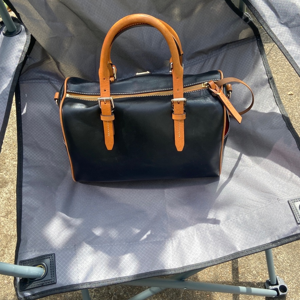 Dooney & Bourke Black Leather Bag with Gold Logs.
Has red interior.